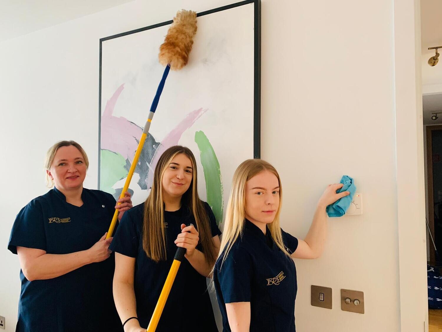 three woman cleaning the wall & painting