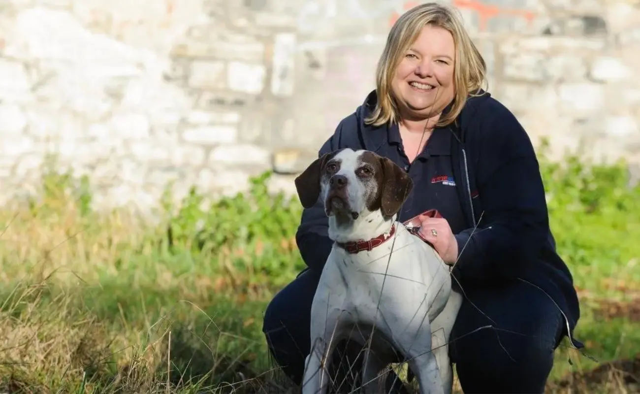 a woman smiling with a dog