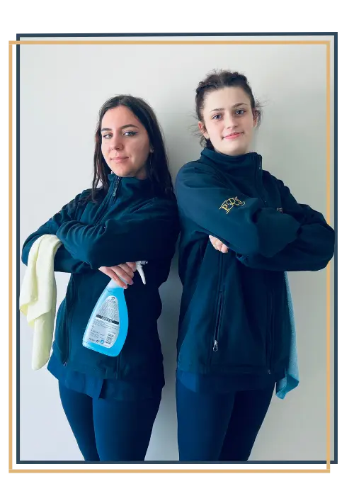 Two women posing holding cleaning products